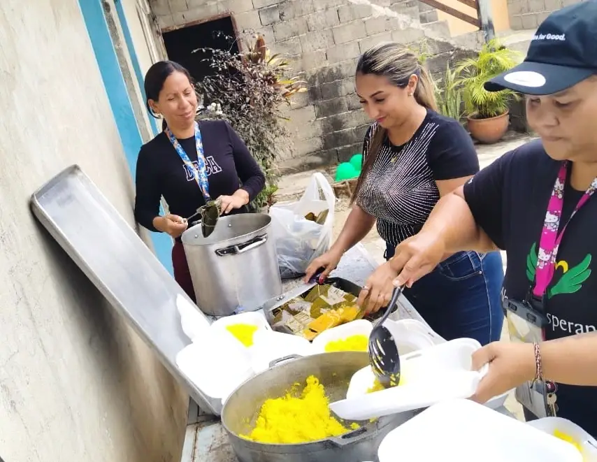 Un grupo de mujeres emplatan alimentos.