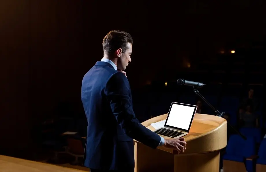 Persona dando un discurso en un escenario