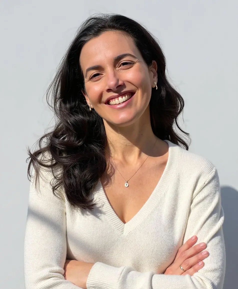 A woman standing with a smile and her arms crossed