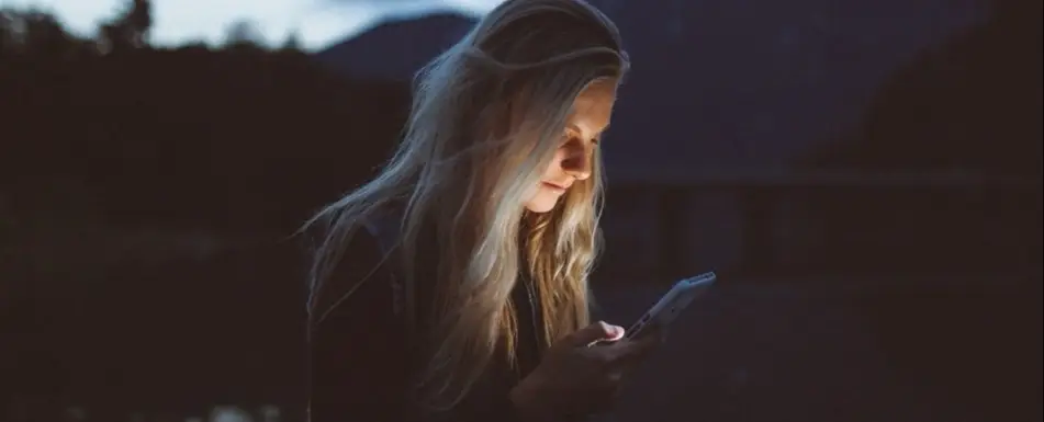 A woman looking down at her phone.