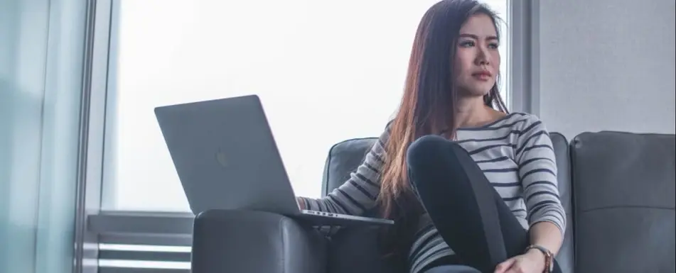 A woman on a couch looks over her shoulder.