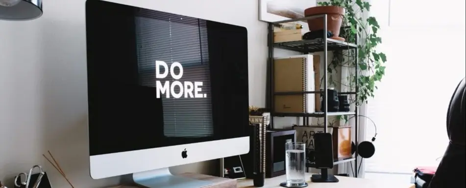 An iMac computer screen on a work desk.