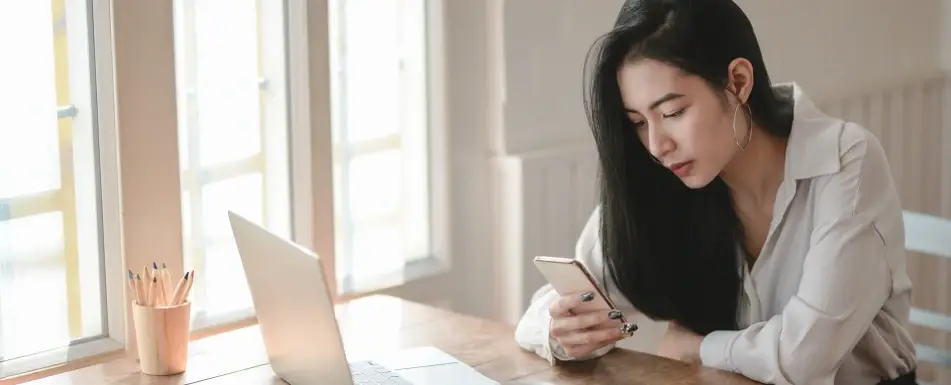 A woman sitting looking at her phone.