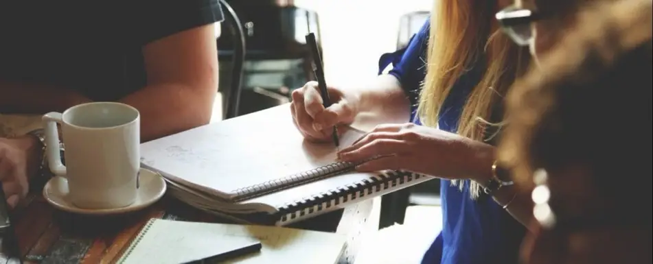 A group of people sitting at a desk working.