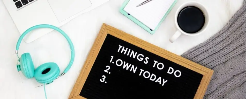 A work desk with a to do list board on it.