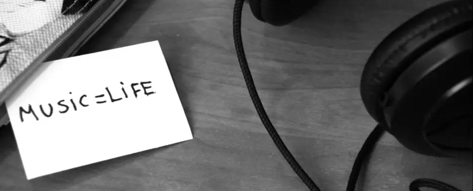 A card that says "Music = life" next to a set of headphones