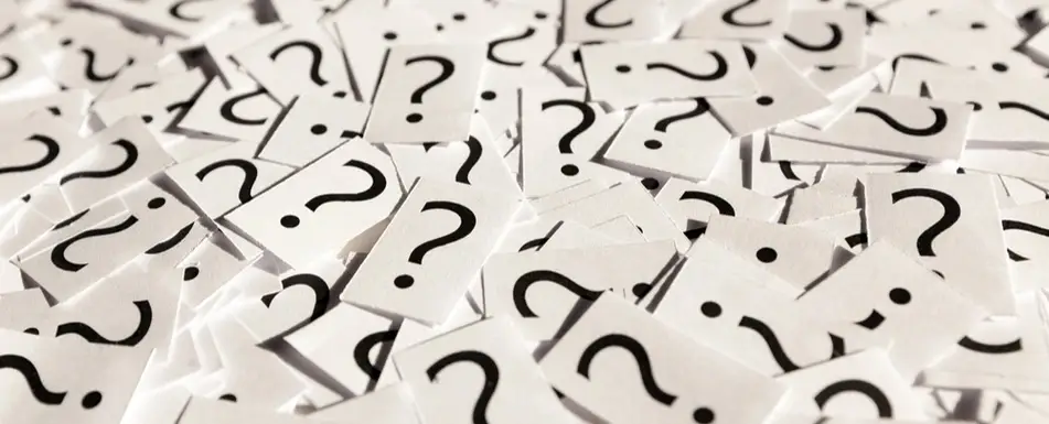 A pile of papers with question marks printed on each one.