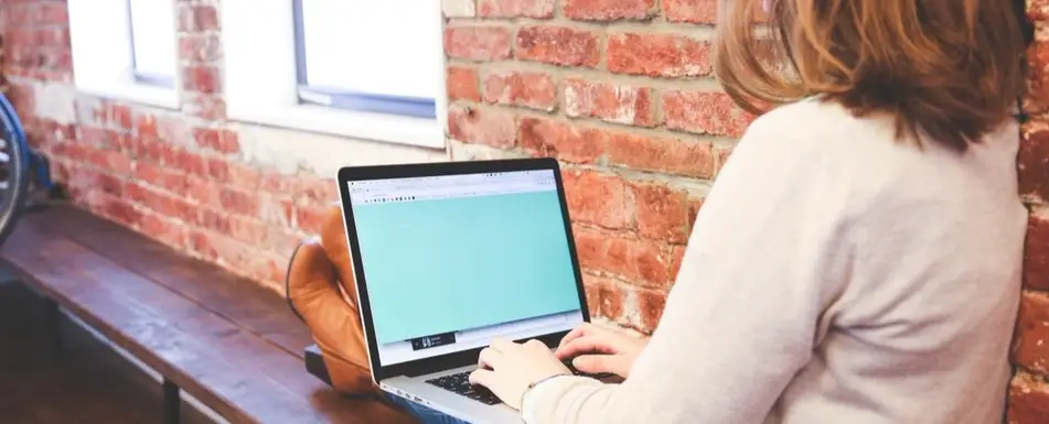 A woman typing on a laptop.