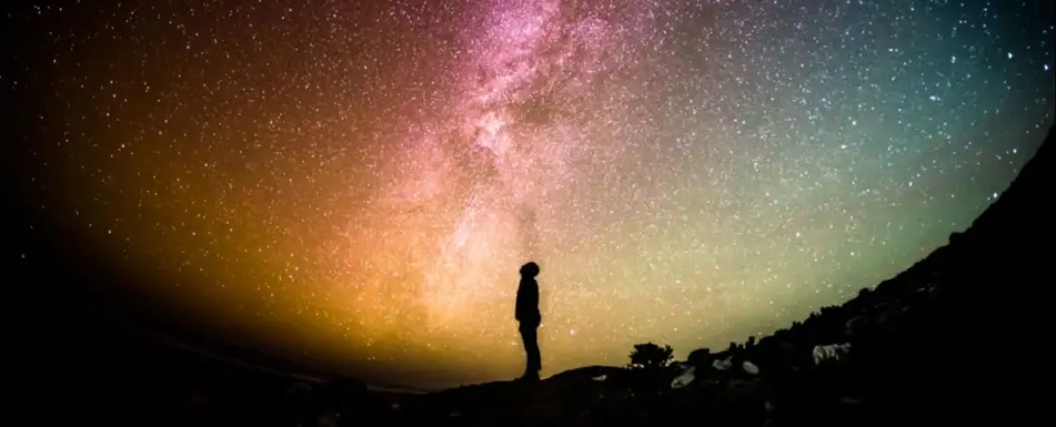 Someone looking up at the sky and looking at the stars.