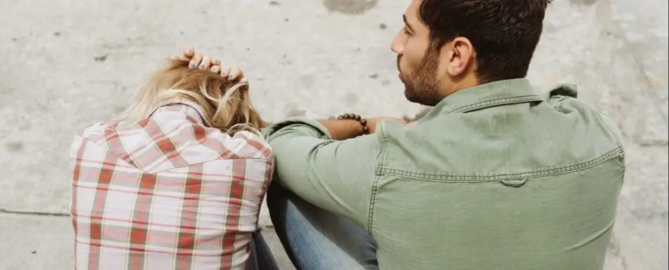 Two people sitting on the ground.