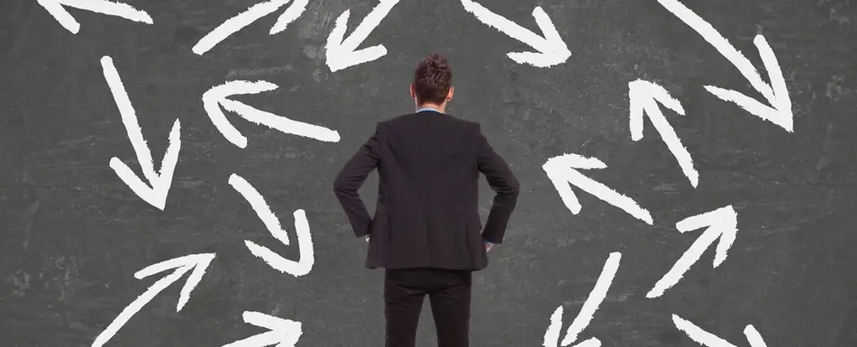 A person in front of a chalkboard with drawings of arrows on it.