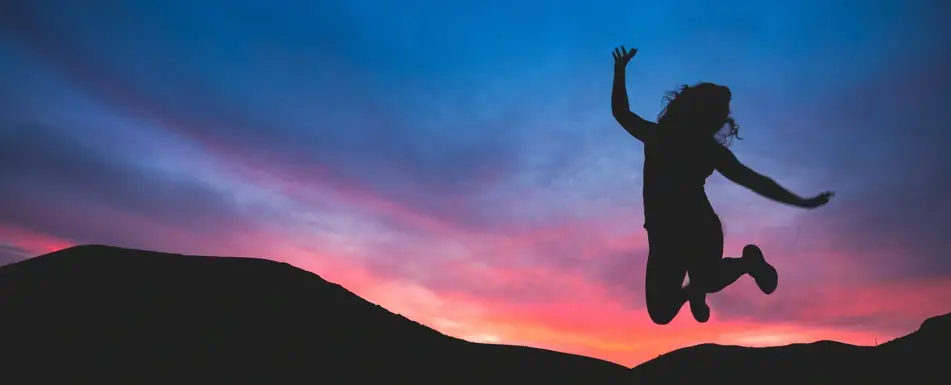 woman jumping at sunset