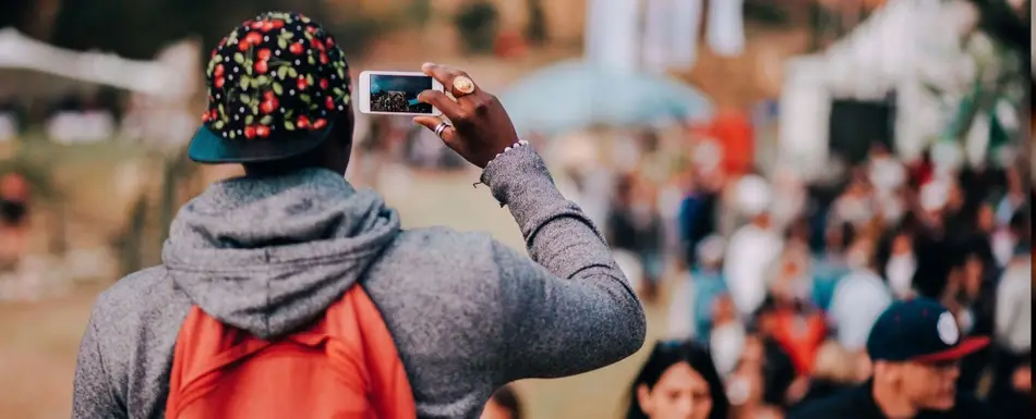 A person taking a picture of a crowd with their smartphone.