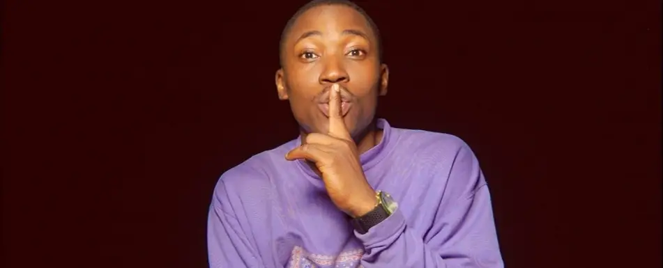 A person making the shhing signal with their finger.