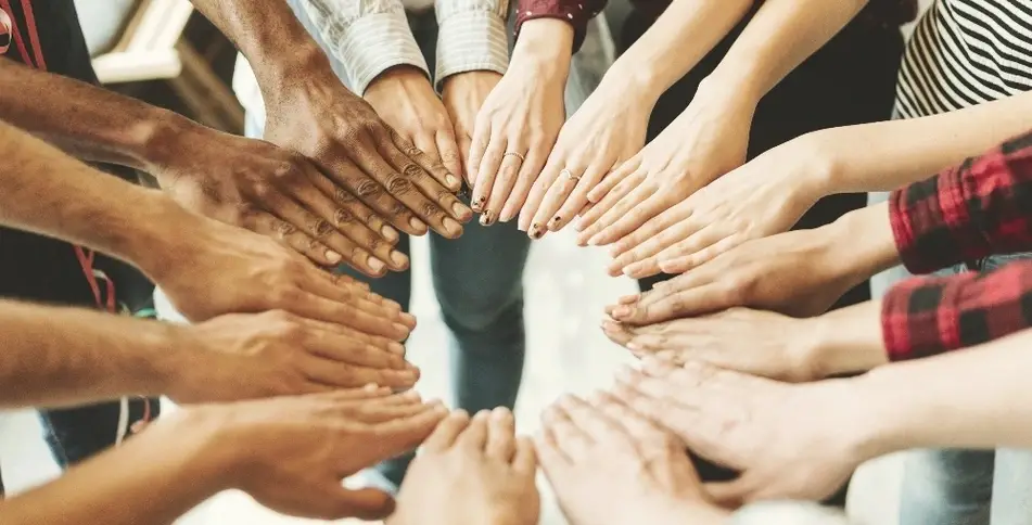 Varias manos unidas formando un círculo