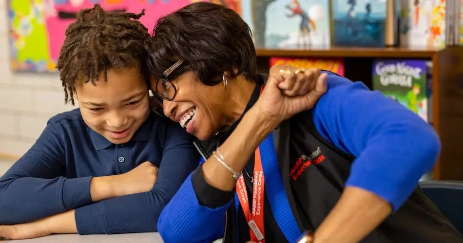an AARP volunteer smiles with a participant in her program