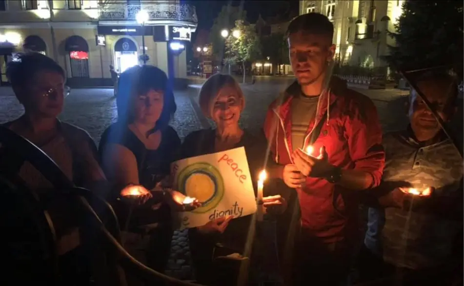 Idealists around the world hold the Idealist logo and candles outside
