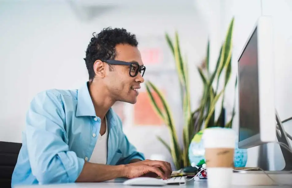Hombre con una computadora sonriendo