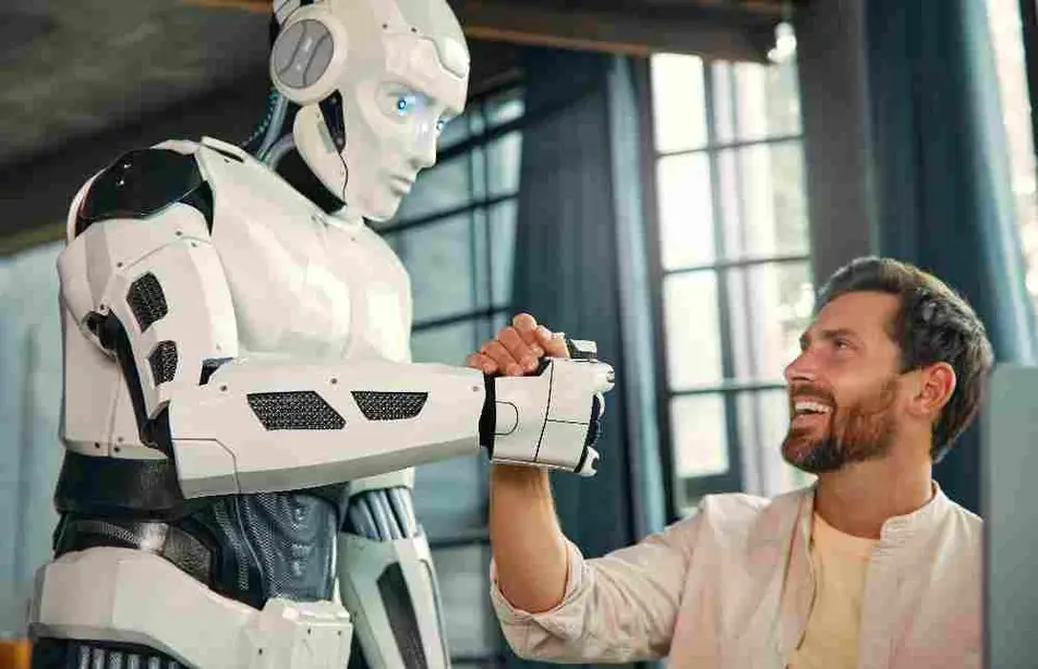Un robot y un hombre sonriente se dan la mano.