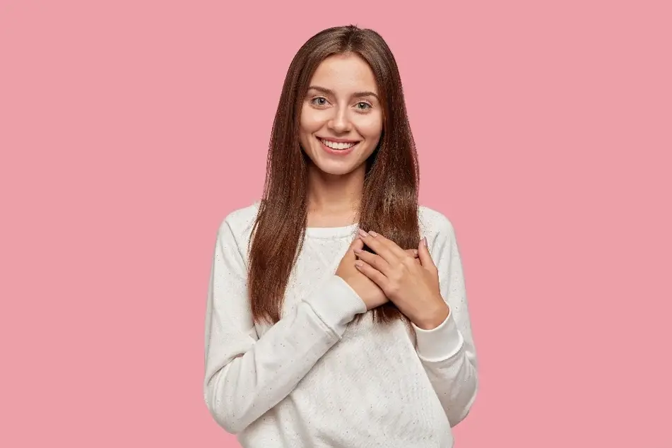 Mujer con tierna sonrisa y gesto de agradecimiento