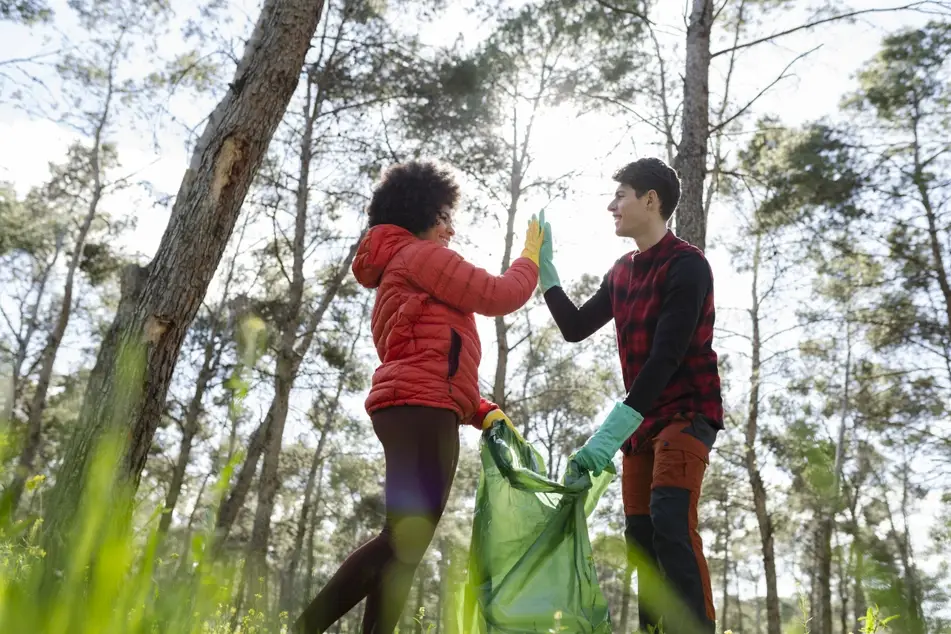 Two volunteers celebrate Giving Tuesday by picking up trash.