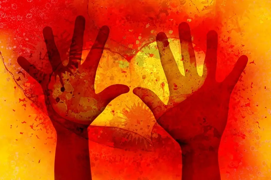 Two hands outstretched with a graphic of a heart over them.