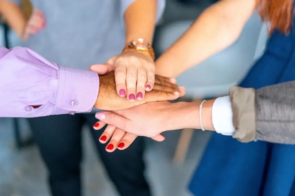 Grupo de personas uniendo sus manos en señal de unidad y apoyo