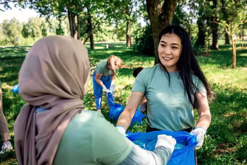 two volunteers clean up trash outside