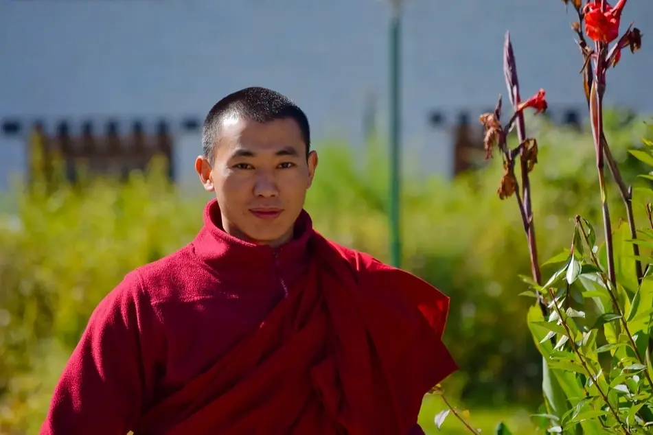 A young Bhutanese man smiles at the camera.