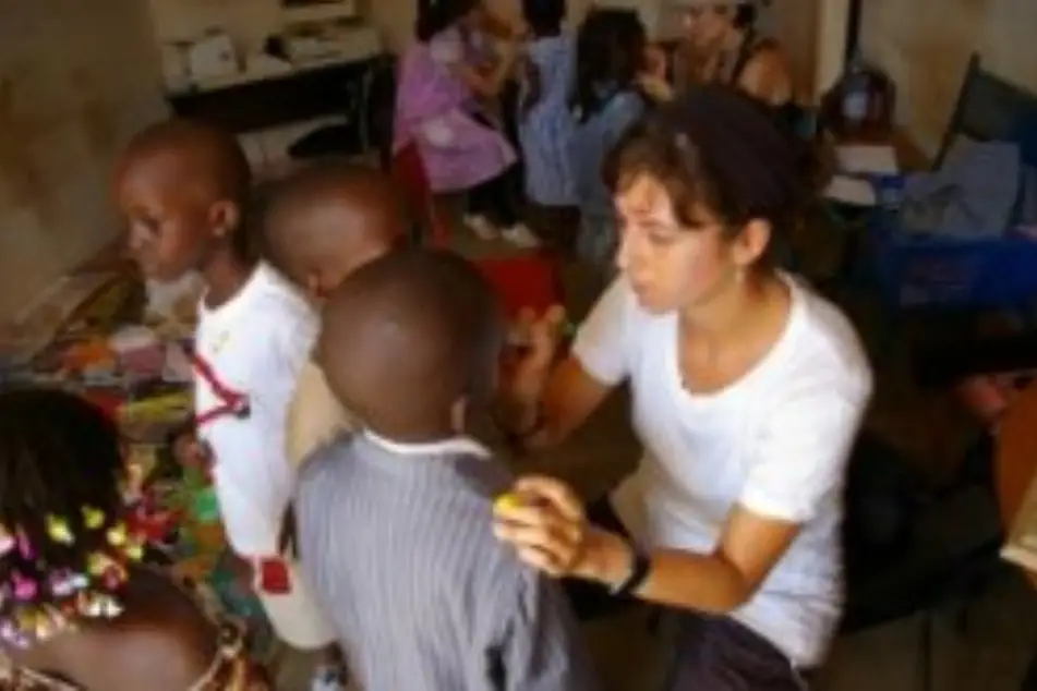 A woman paints a little boy's face.