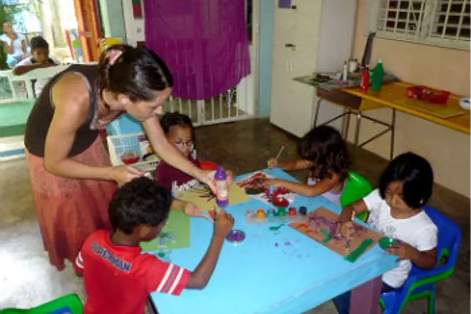 Voluntaria trabajando con niños, haciendo manualidades