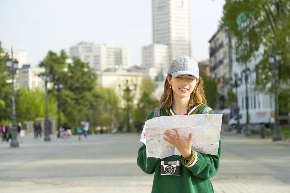 Photograph of a kind city with a tourist looking at a map