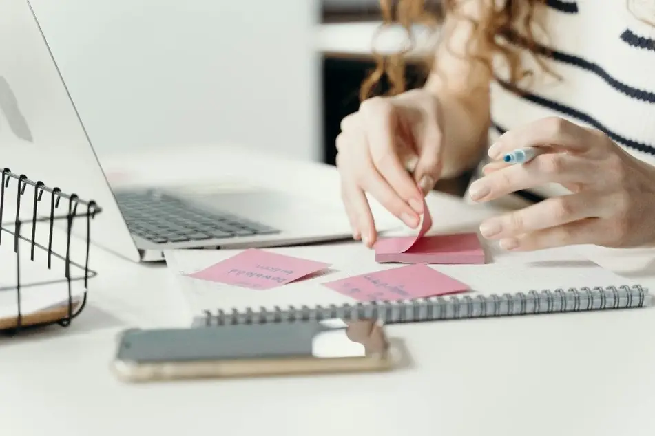 Mujer tomando notas en post its de colores
