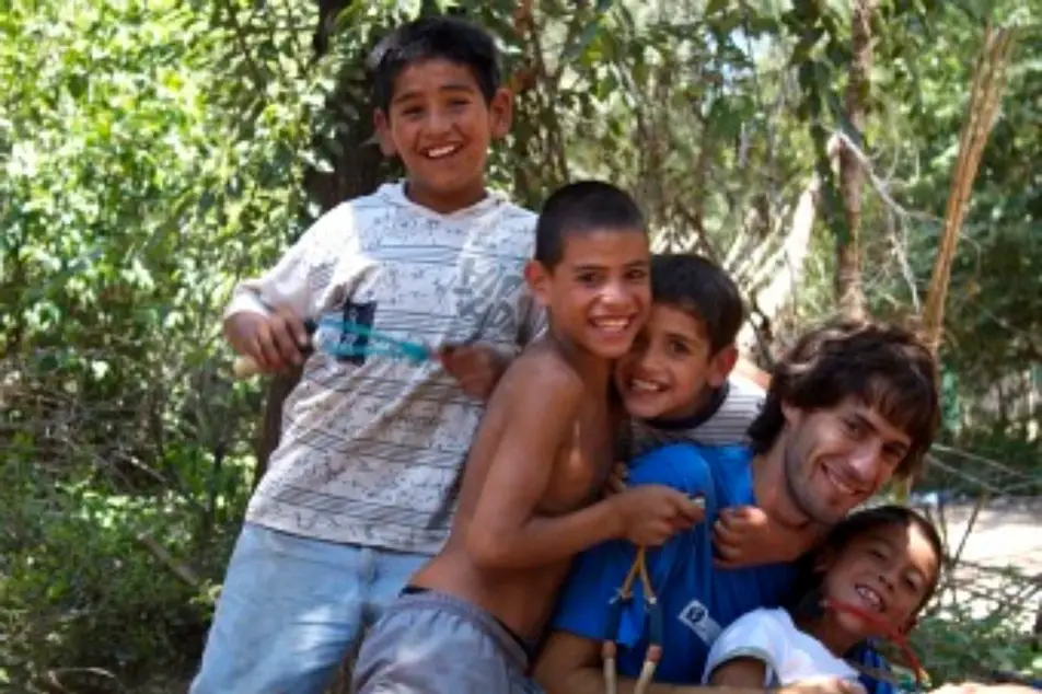 Un voluntario junto a 4 chicos de la comunidad