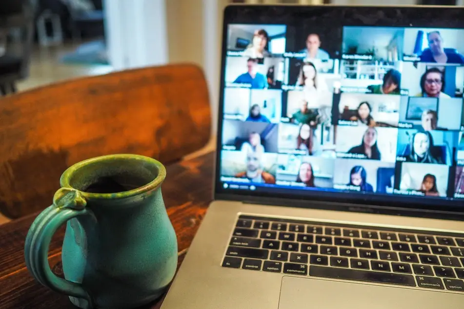 coffee mug next to laptop with Zoom meetoing
