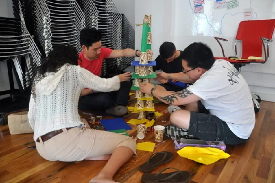 4 personas armando un juego tipo Jenga