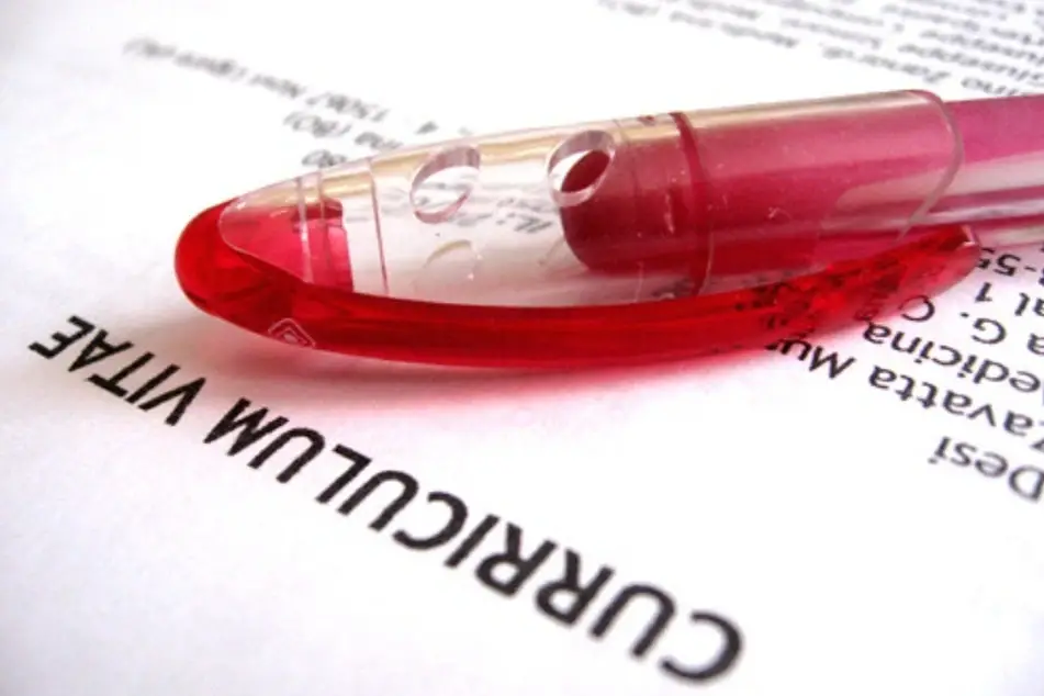 Un esferográfico rojo sobre un curriculum vitae