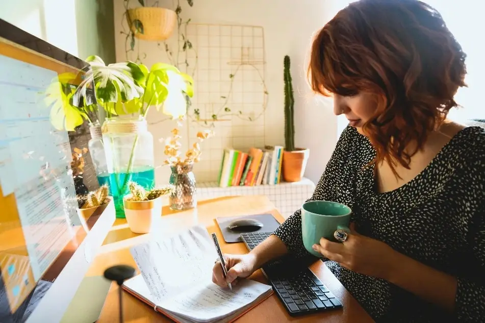 Mujer escribiendo en un cuaderno de notas
