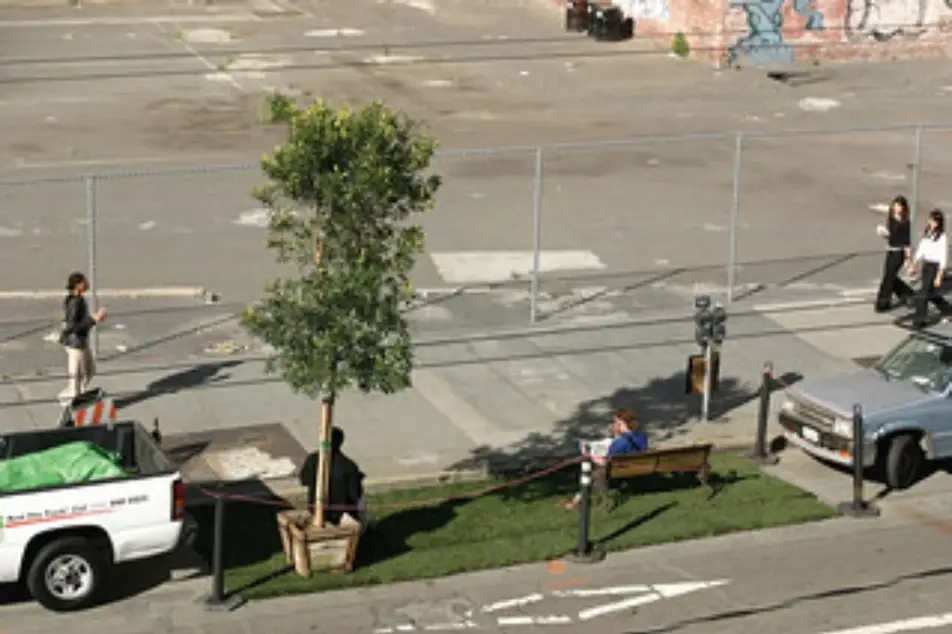 Un parque pequeño en medio de un estacionamiento