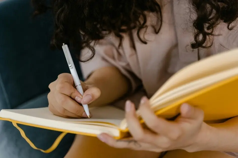 Mujer tomando notas en una libreta