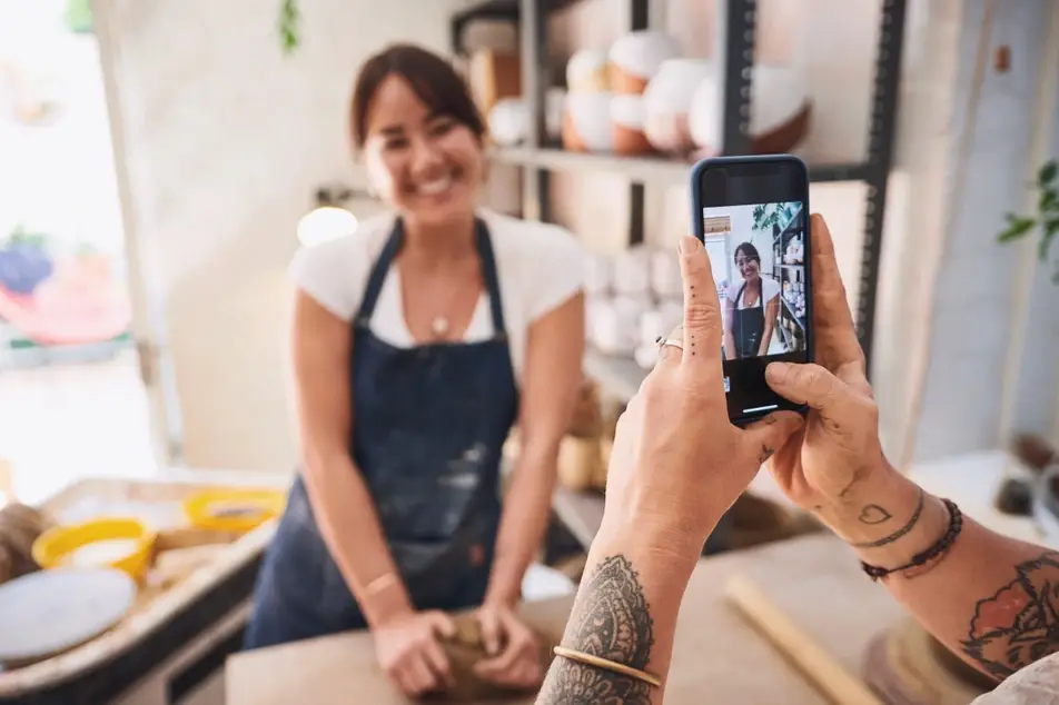 Woman in pottery studio poses for an Instagram photo