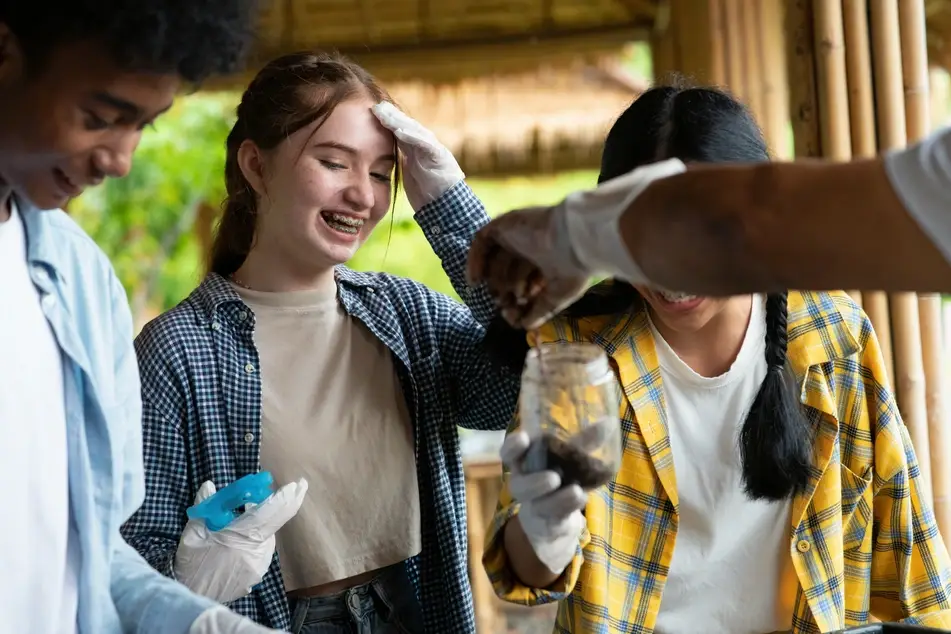 Three teenagers volunteer at a community garden together