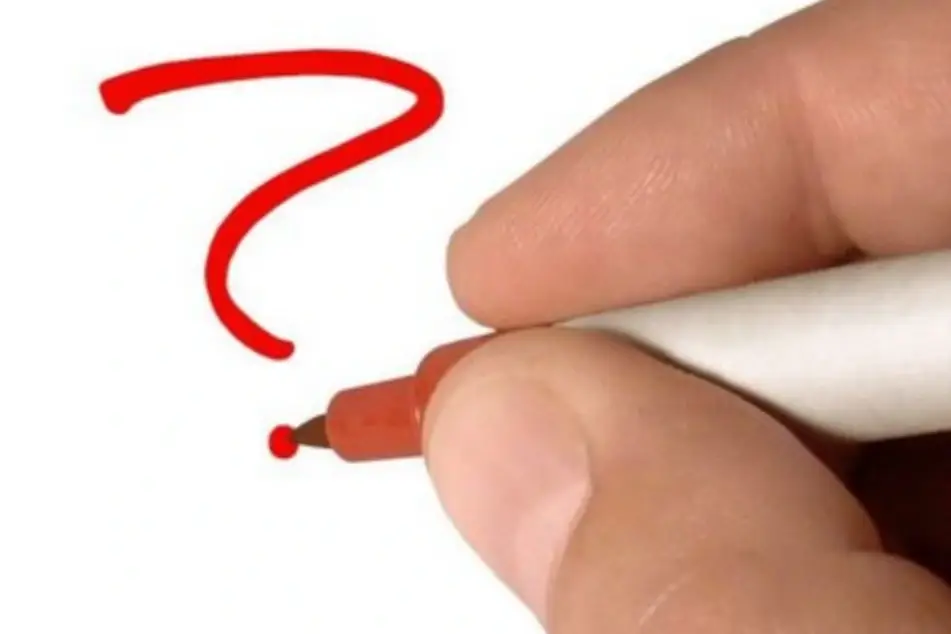 Una mano escribiendo un signo de interrogación