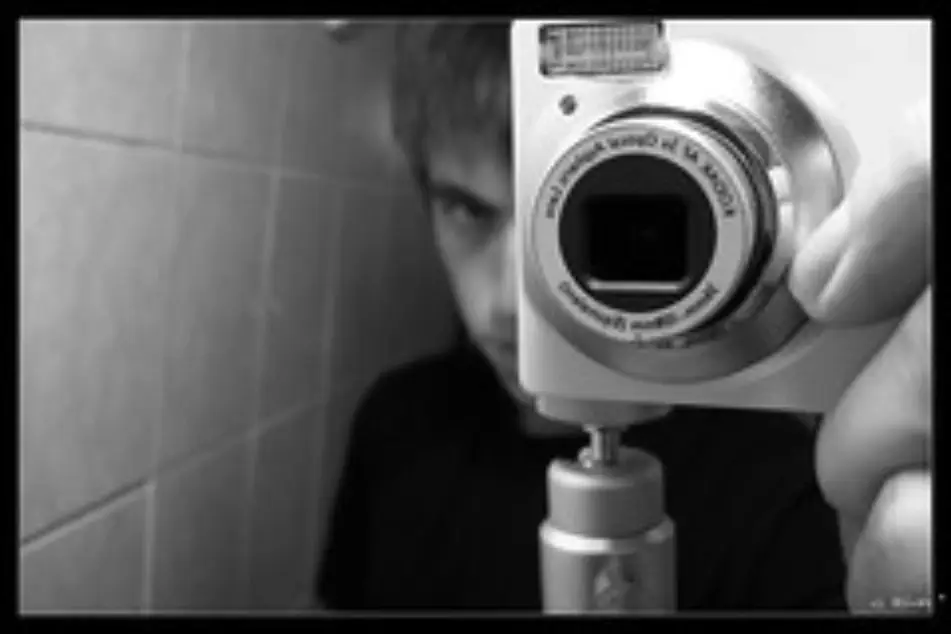 Un chico tomando una foto en blanco y negro