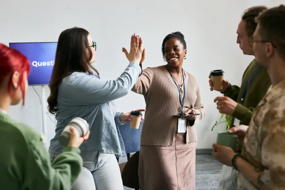 Diverse volunteers high five at a volunteer orientation