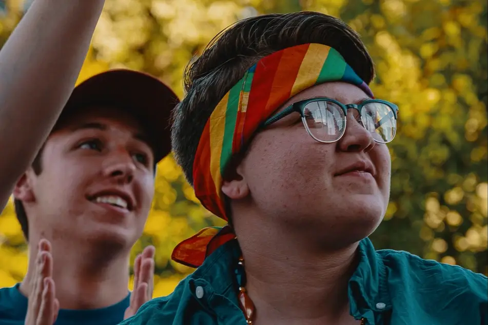 Two people with rainbow bandana smiling, image for Idealist's blog post 3 Things to Keep in Mind When You Come Out at Work
