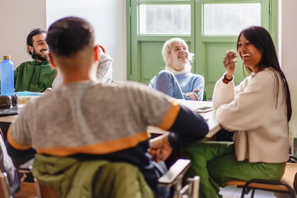 Group of volunteers laught inside around a table
