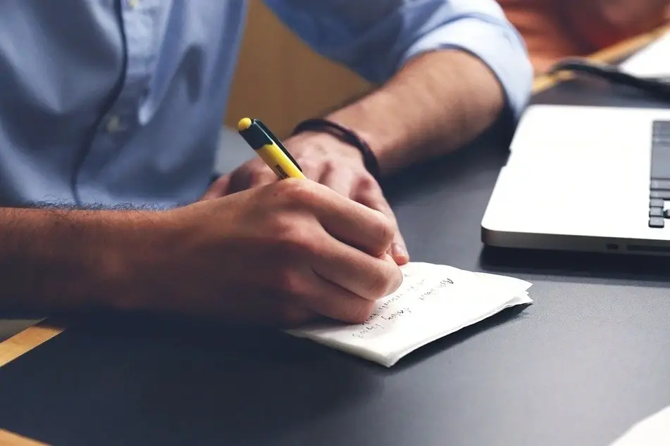 persona tomando notas en un cuaderno