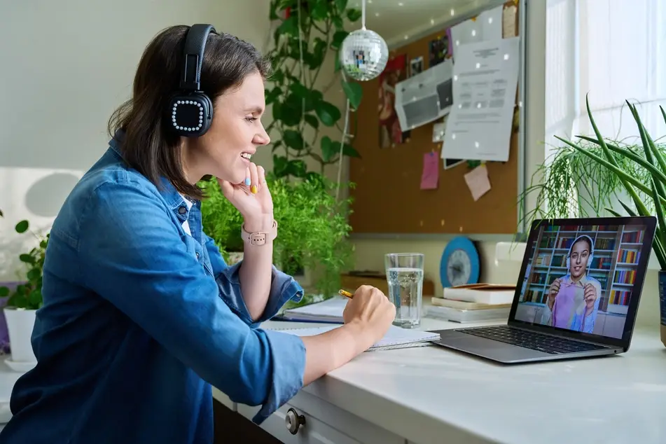 teenage girl volunteers remotely and smiles at computer screen