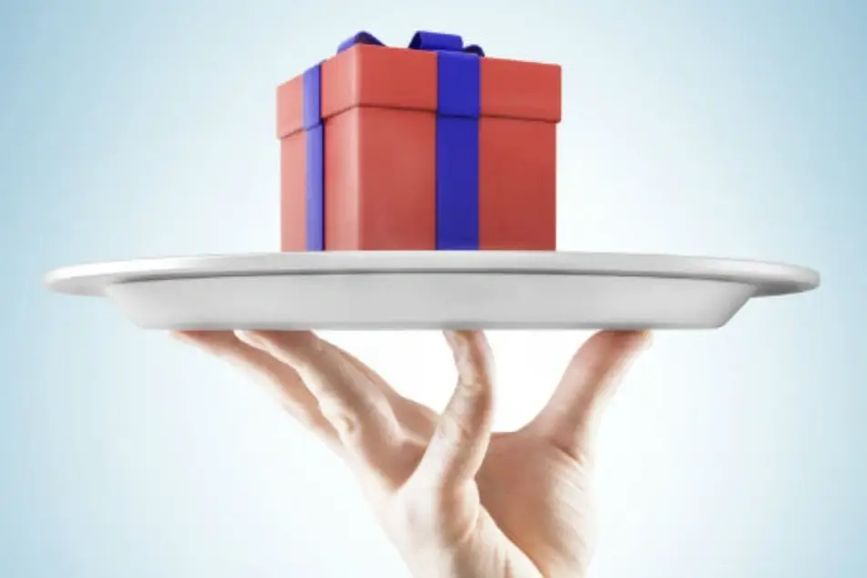 Una mano sosteniendo una bandeja con un regalo